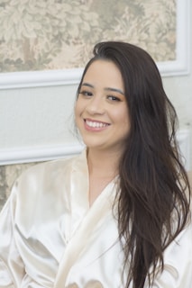 A smiling therapist welcoming a client into the spa environment.