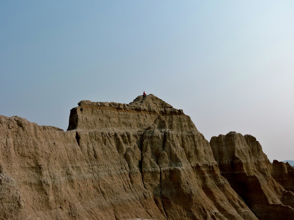 person standing on brown rock formation during daytime