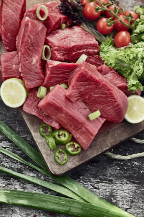 Close-up of fresh liver cuts arranged on a traditional butcher's wooden board.