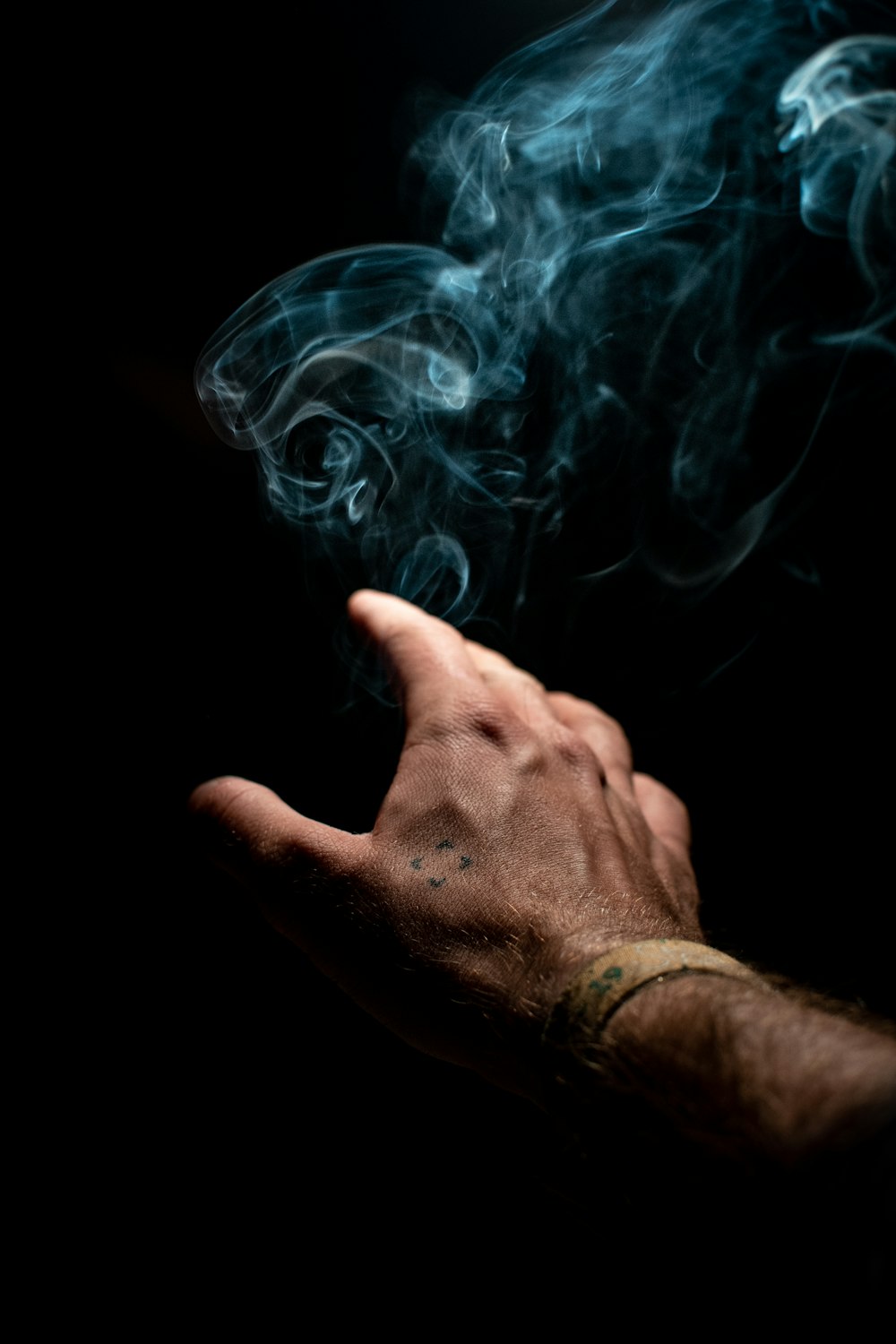 persons hand with blue smoke