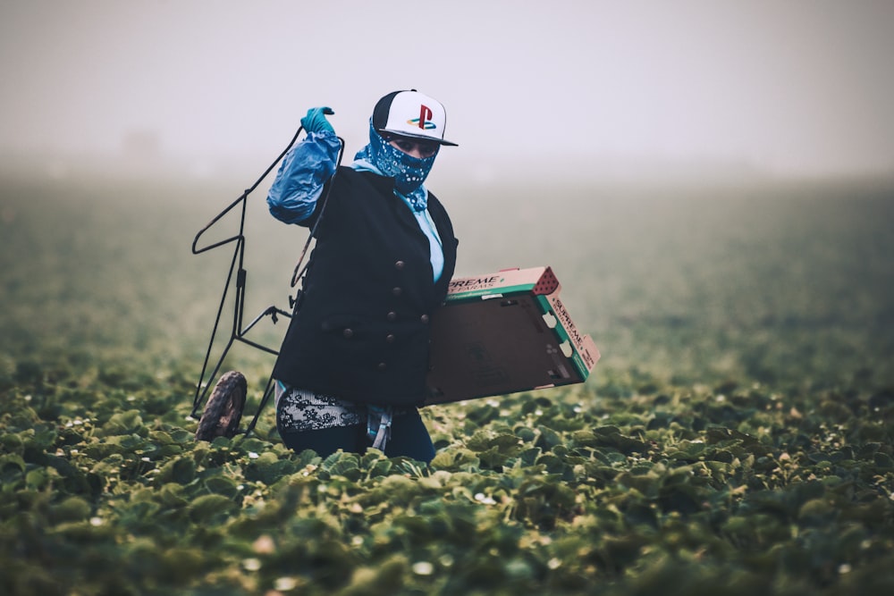 Homme en veste bleue portant un casque blanc debout sur un champ d’herbe verte pendant la journée