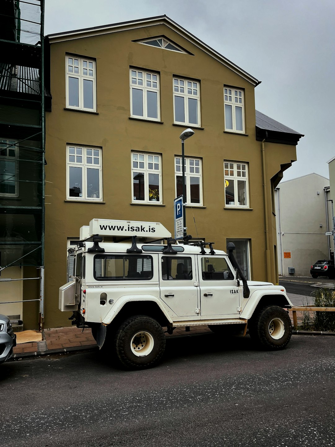 white and black jeep wrangler parked in front of brown concrete building during daytime