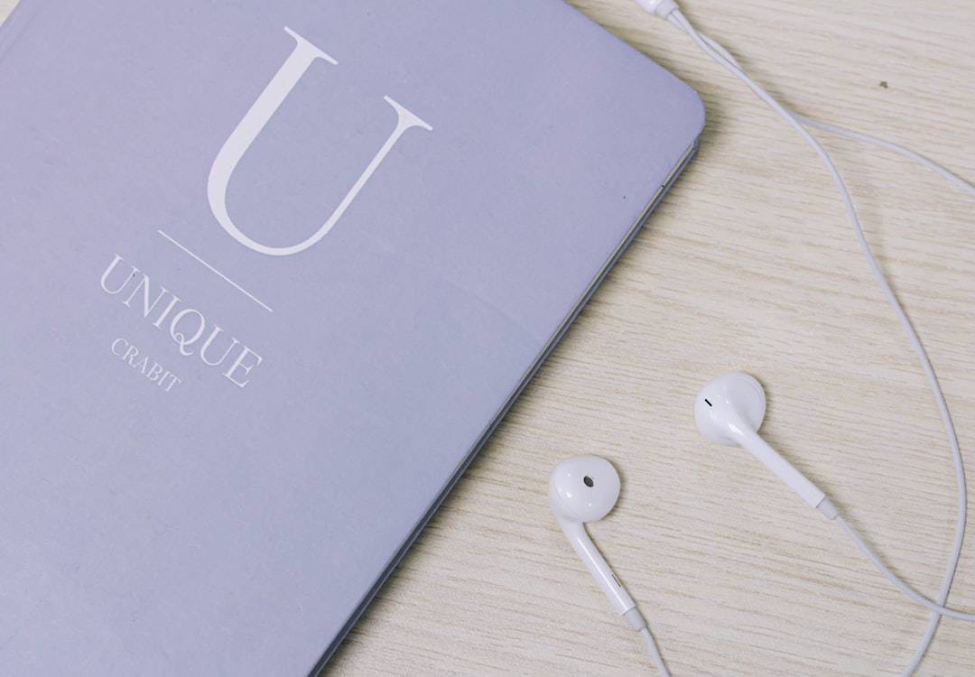 white earbuds on brown wooden table