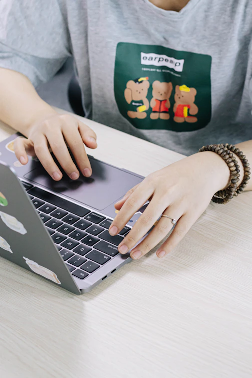 person using macbook pro on white table