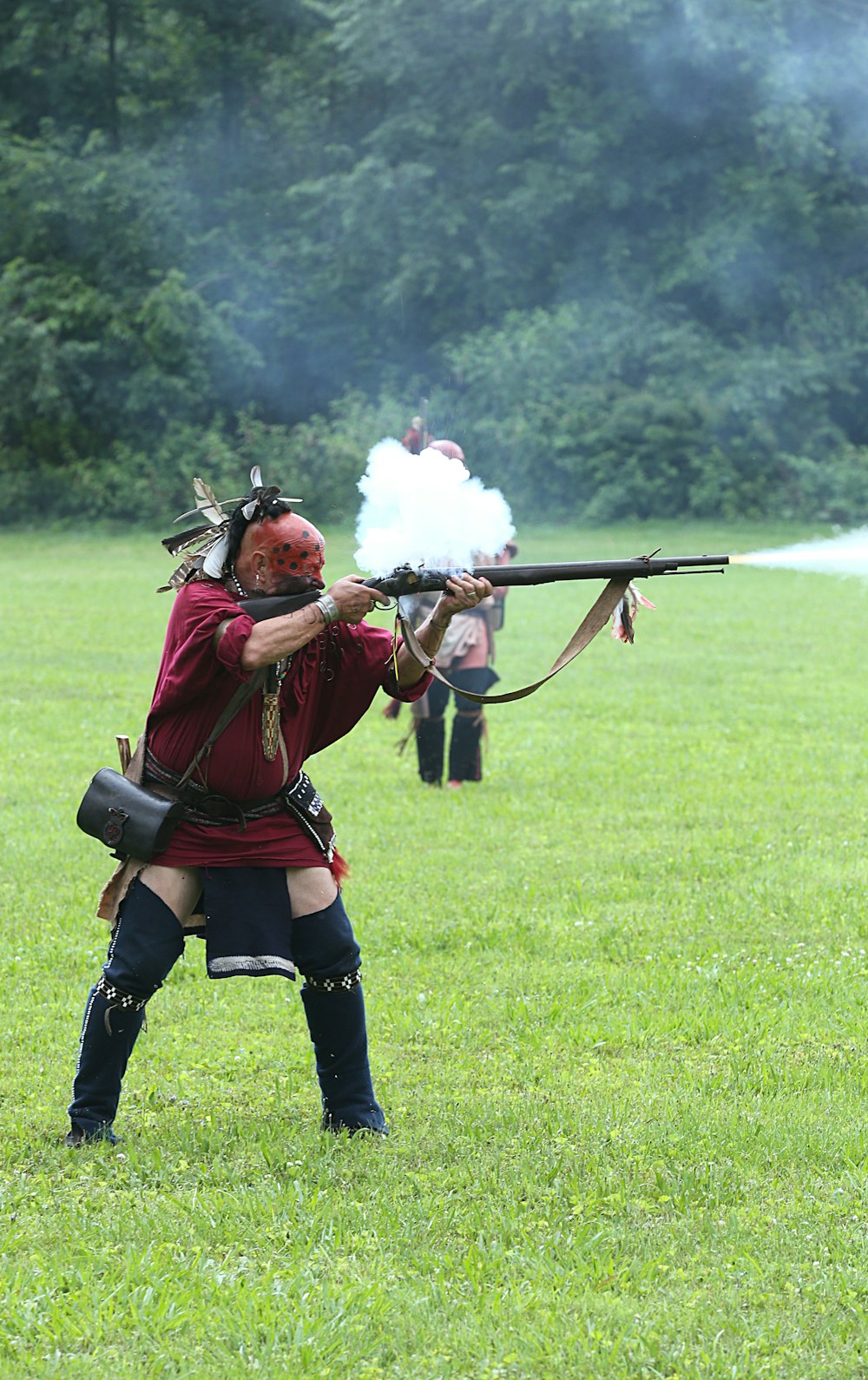 man in red and black coat holding rifle