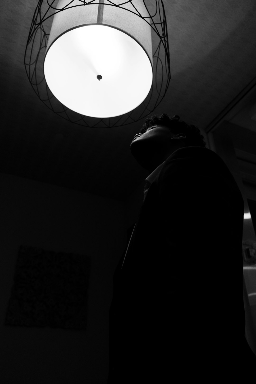 man in black hoodie under white ceiling lamp