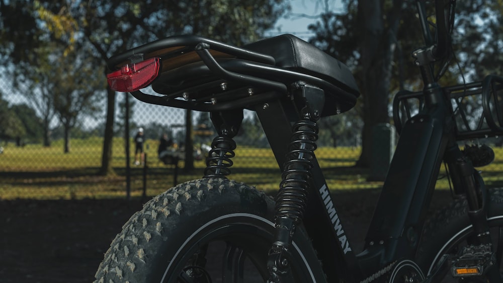 black motorcycle near green trees during daytime