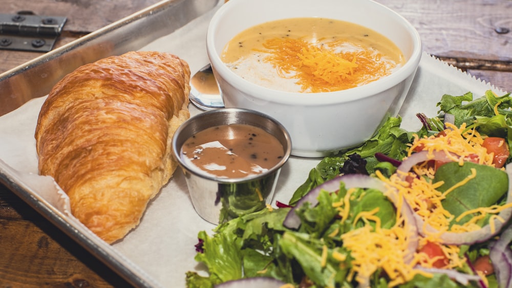 white ceramic bowl with soup beside bread