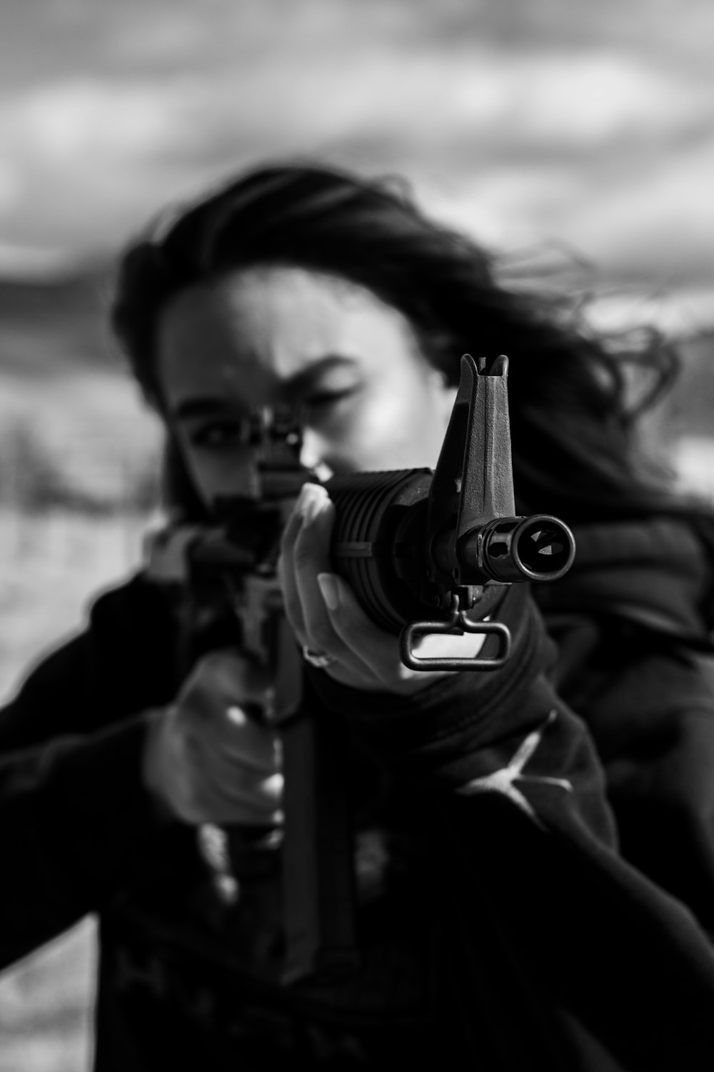 grayscale photo of man holding rifle