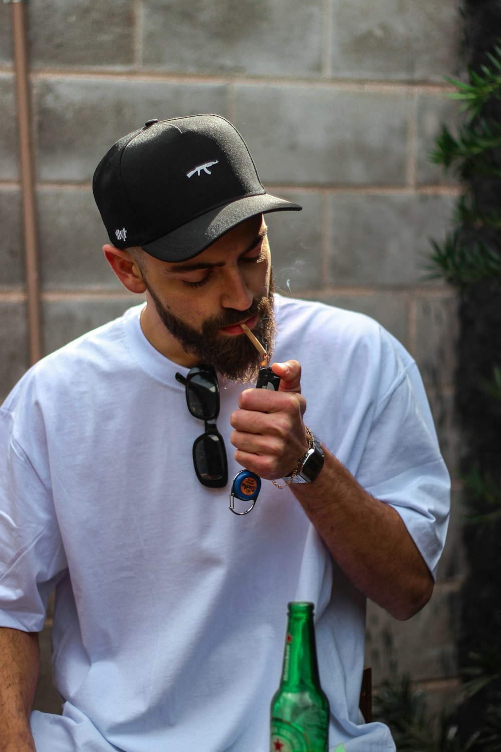 man in white crew neck t-shirt wearing black cap and black sunglasses