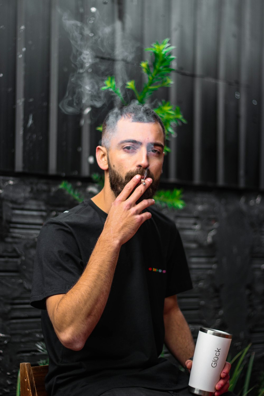 man in black polo shirt smoking cigarette