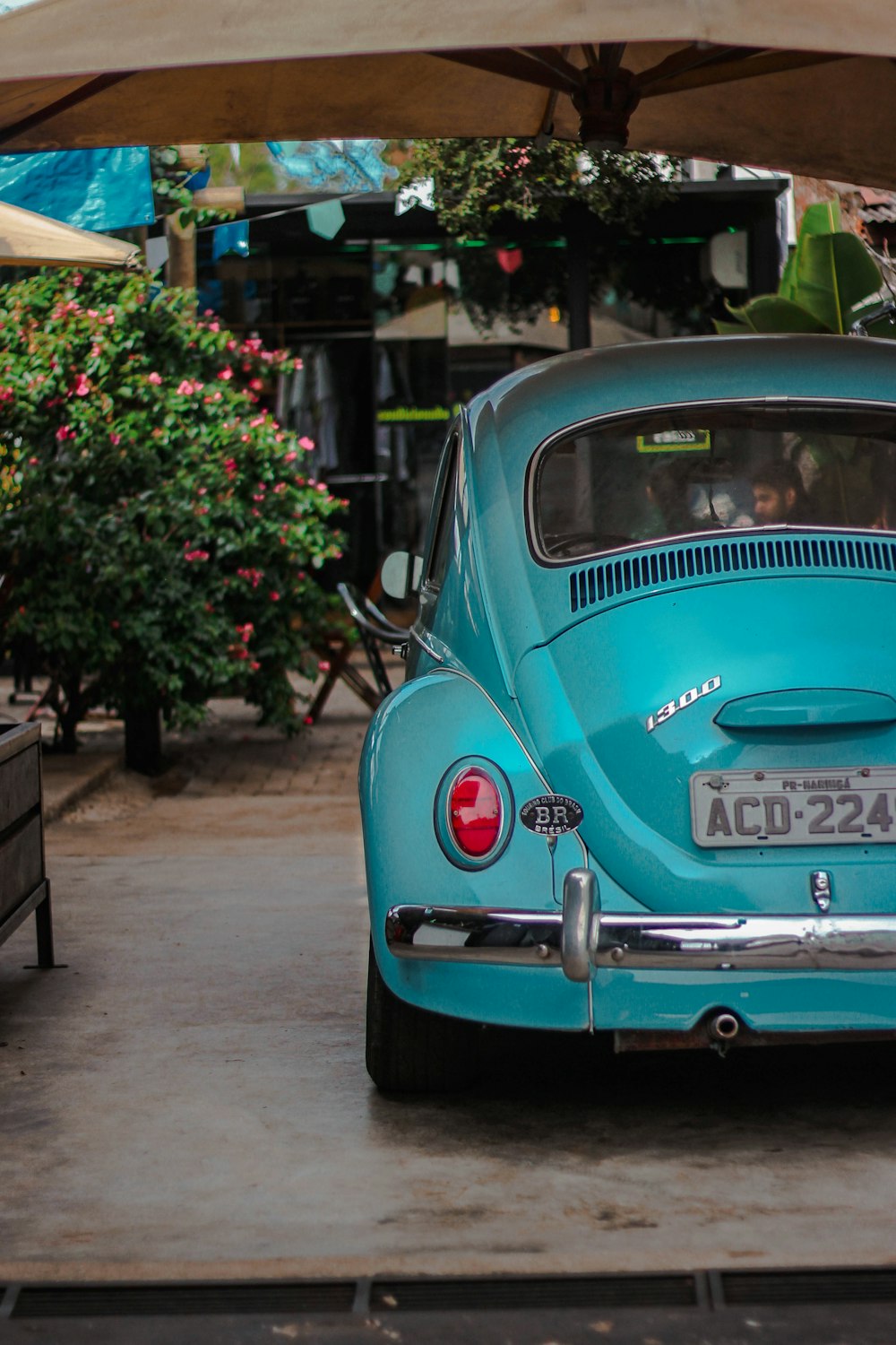 blue volkswagen beetle parked on sidewalk during daytime