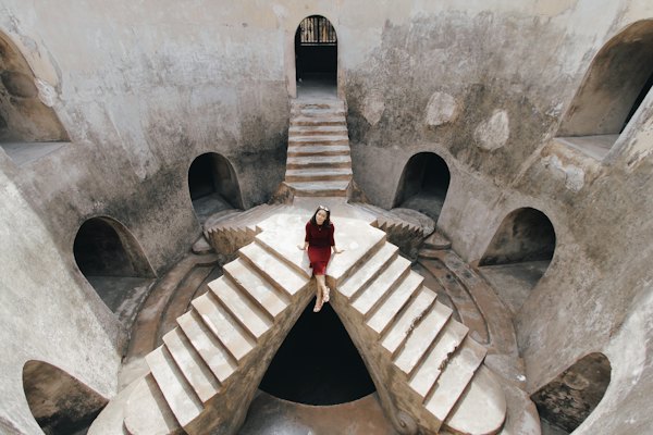 Person in red jacket standing on brown concrete stairs — Yogyakarta, Indonesia