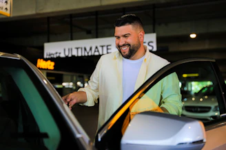 A happy customer handing over car keys to a smiling Autovėjas agent.