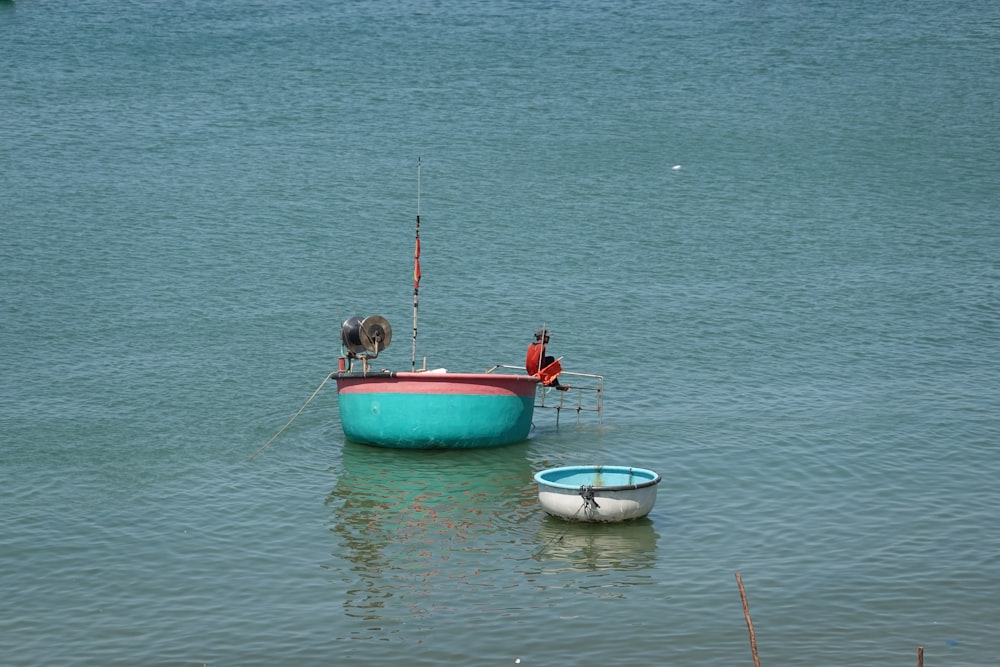 2 person in red and blue boat on sea during daytime