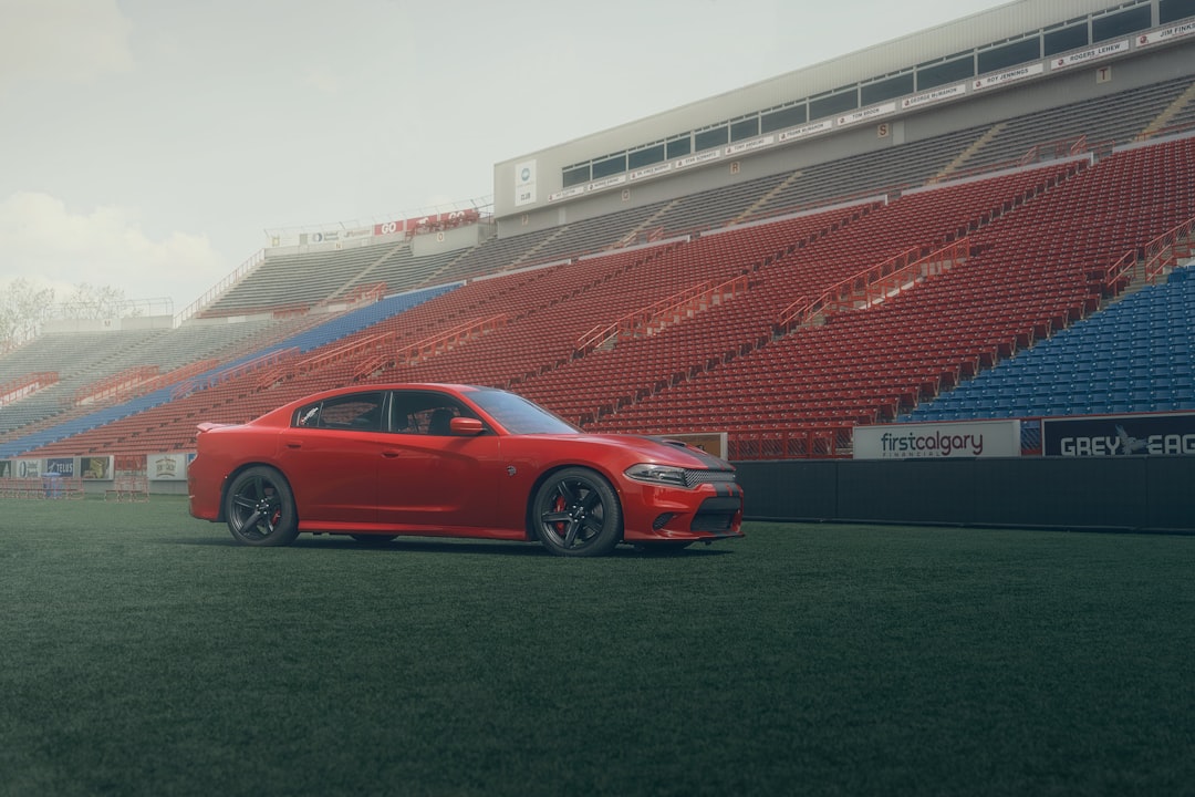 red coupe parked on green grass field