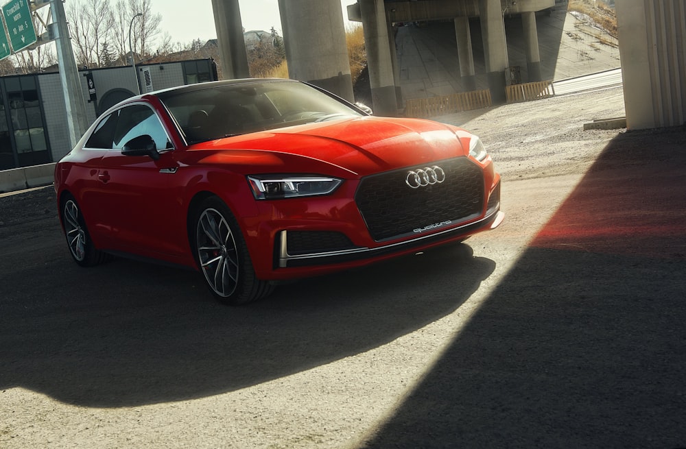 red audi coupe parked on gray concrete pavement during daytime