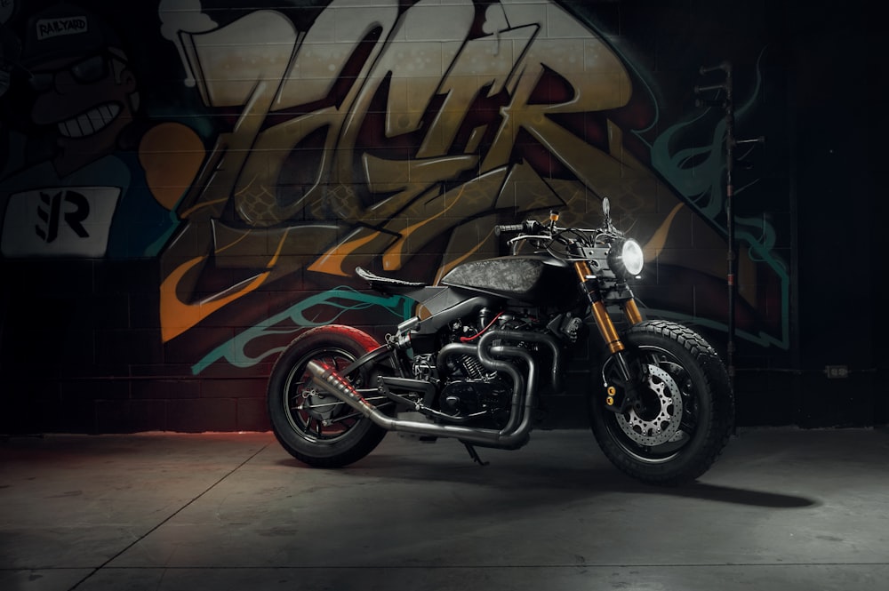 black and red motorcycle parked beside wall