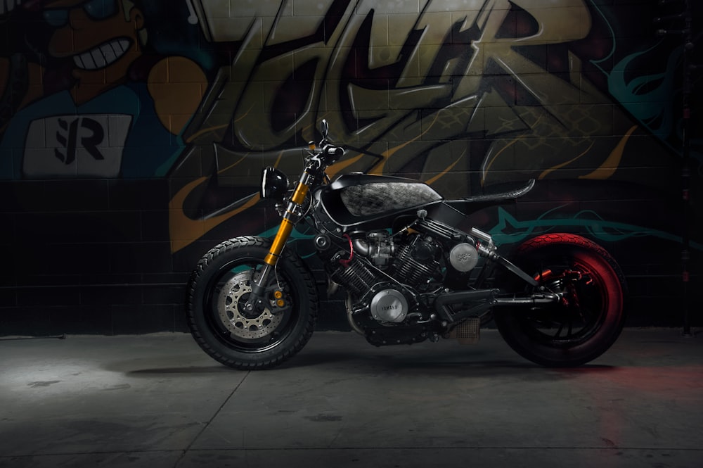 black and silver motorcycle parked beside brown and white wall