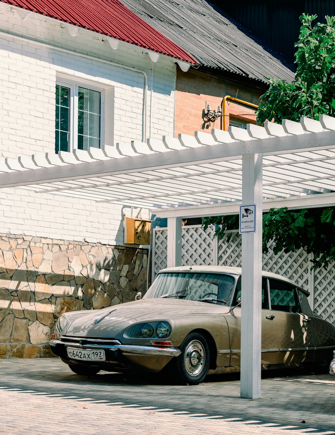 black sedan parked beside brown brick wall