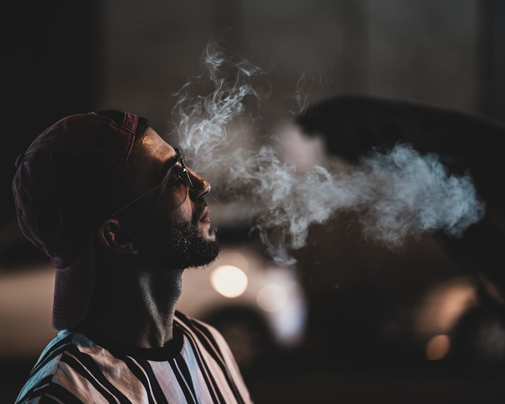 man in black and white striped shirt smoking