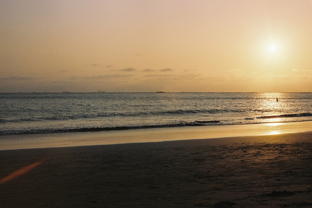 sea waves crashing on shore during sunset