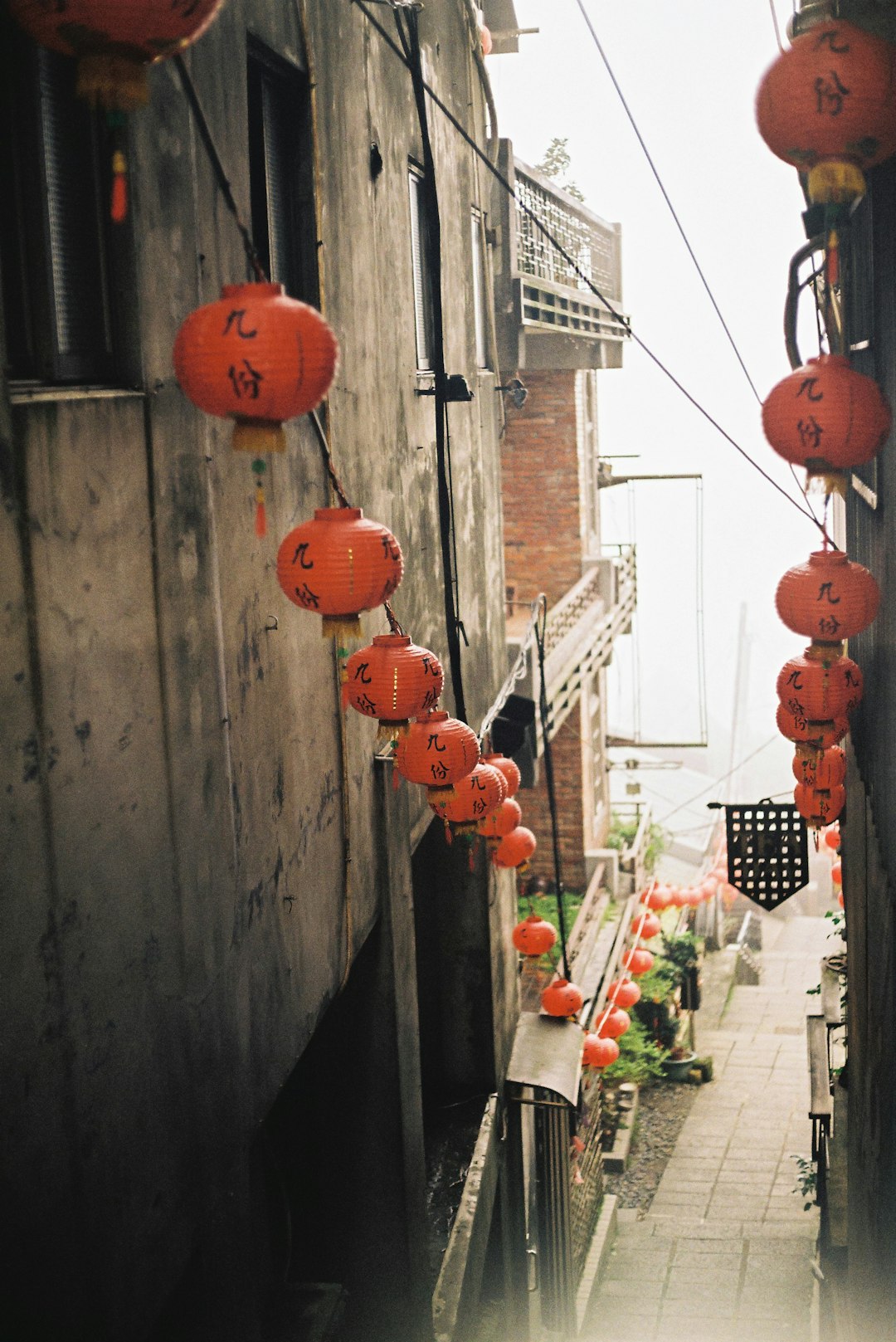 red paper lantern hanging on brown wooden wall during daytime