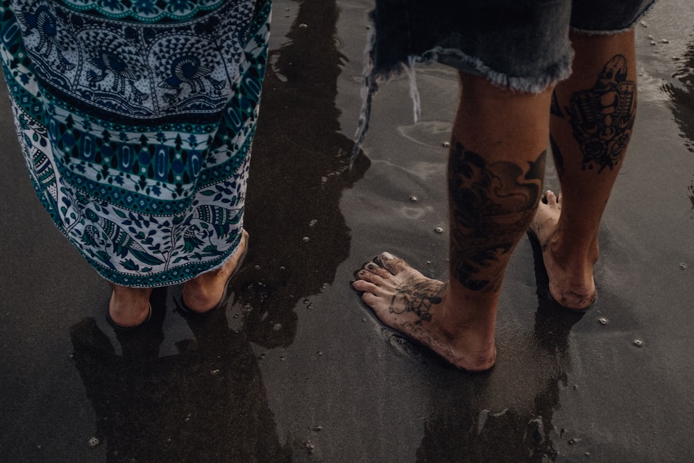 person in blue and white floral skirt standing on wet ground