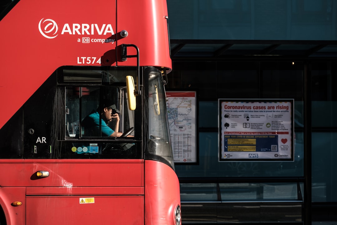 red and black bus in front of building