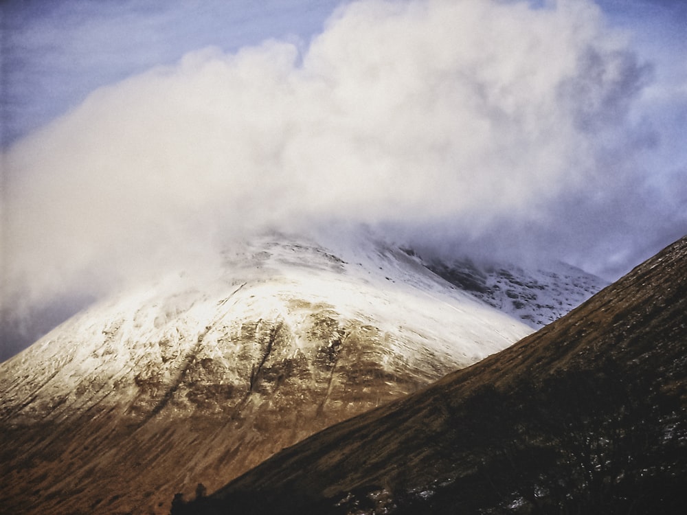 montagna marrone e bianca sotto nuvole bianche durante il giorno
