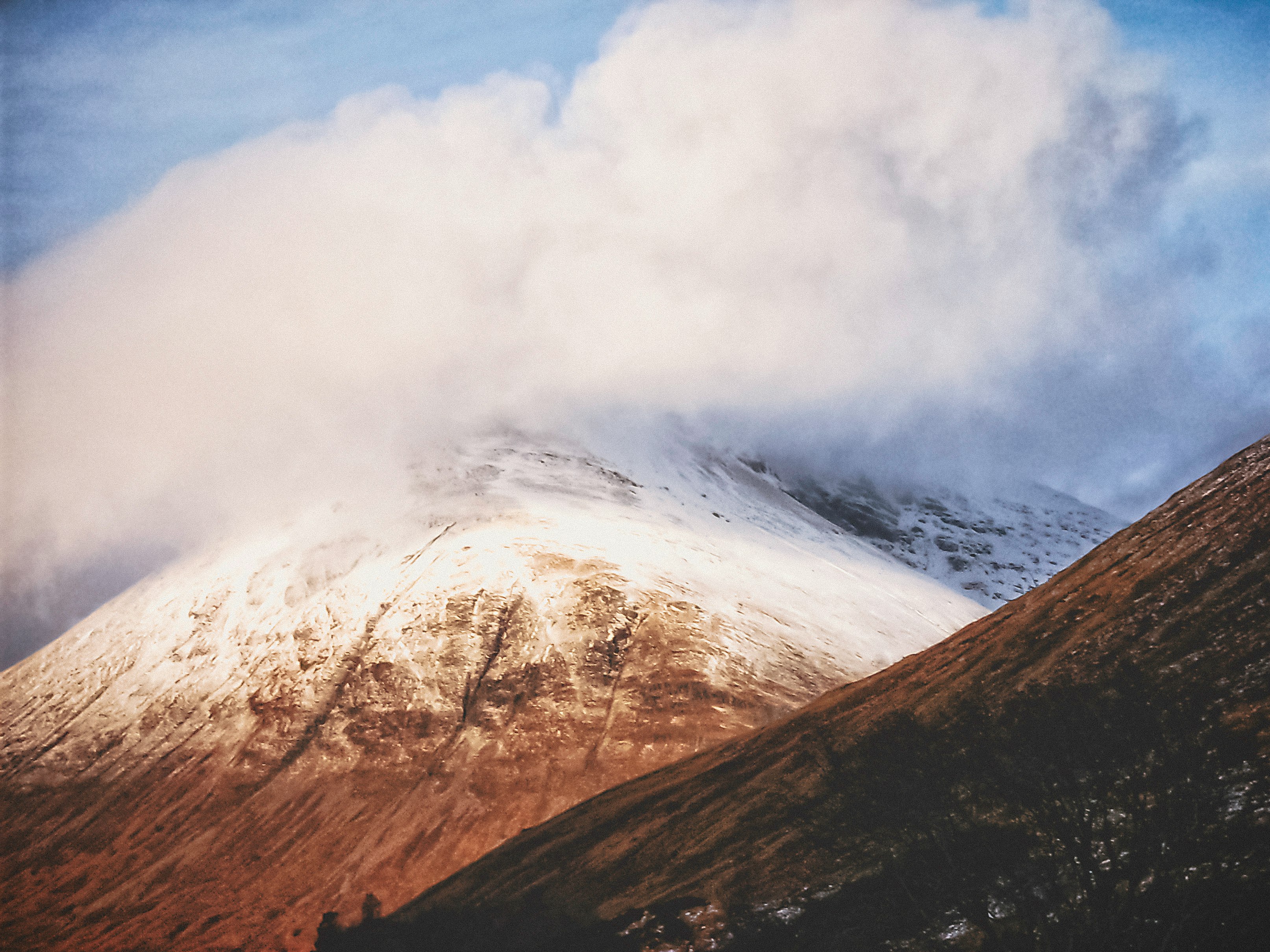 brown and white mountain under white clouds during daytime