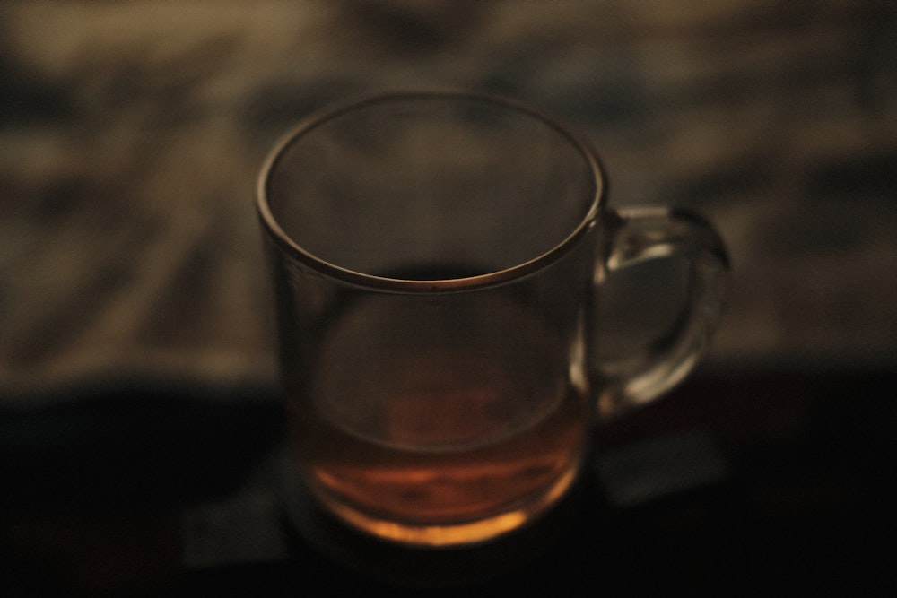 clear glass mug with brown liquid