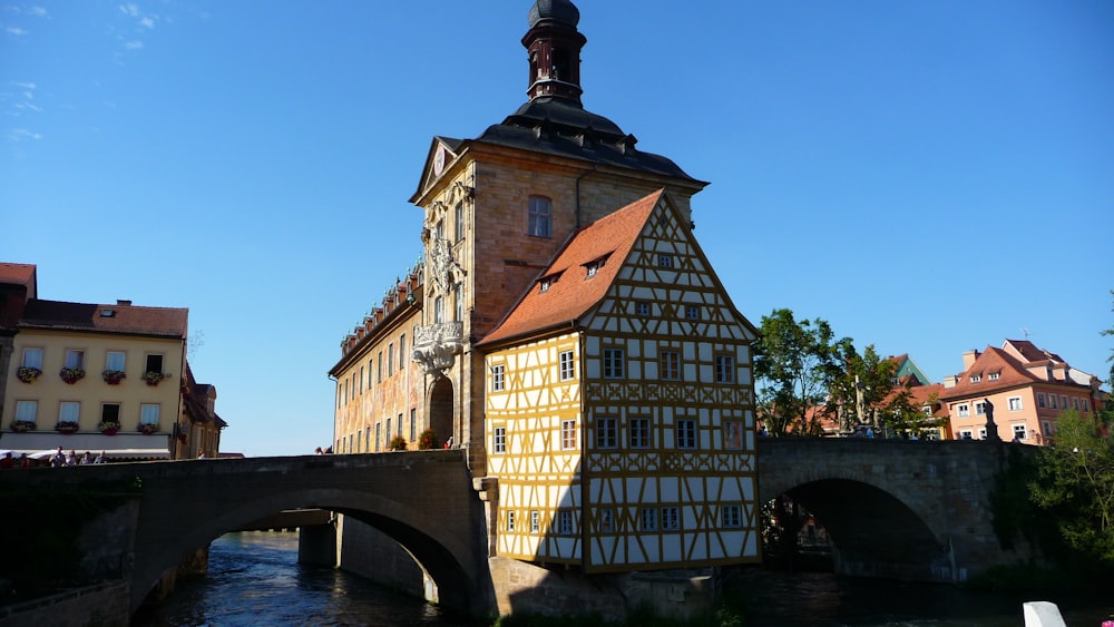 Bâtiment en béton brun et beige près de la rivière pendant la journée