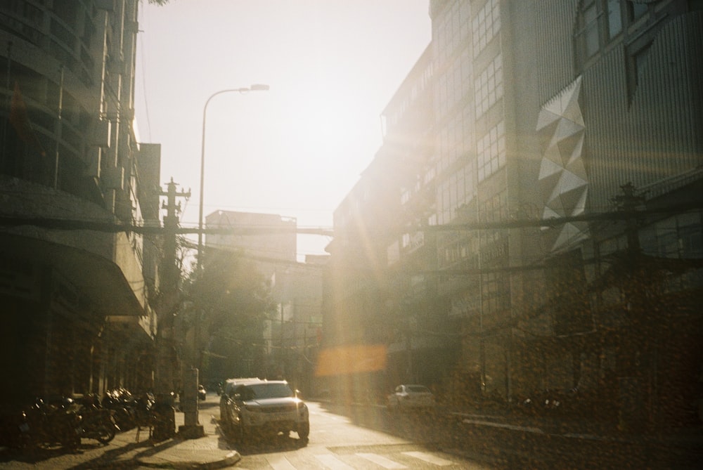 cars on road between high rise buildings during daytime