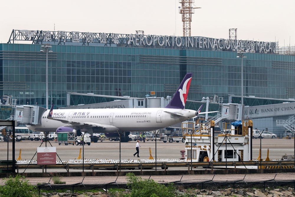 white and blue airplane on airport during daytime