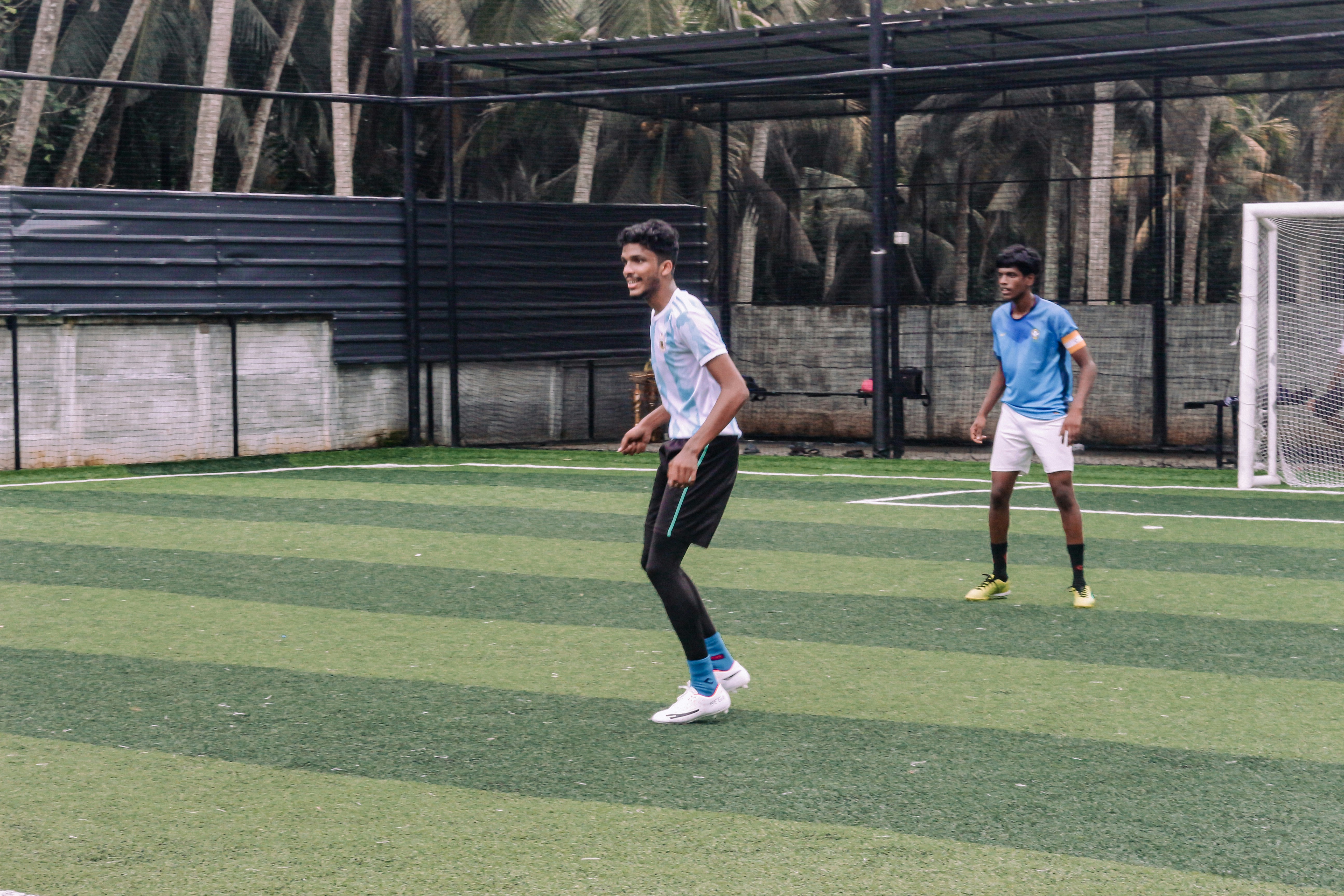 freundschaftsspiel - man in white shirt and black pants running on green grass field during daytime