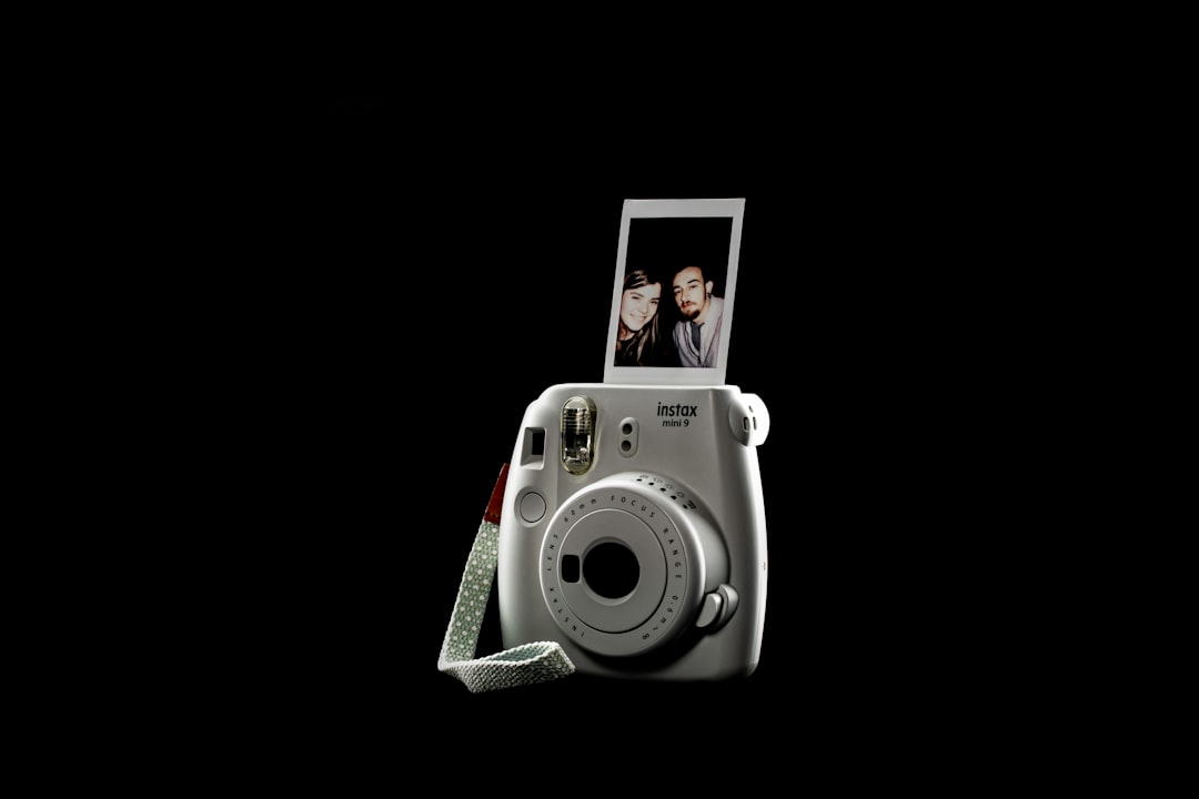 white and gray camera with picture of man in black suit