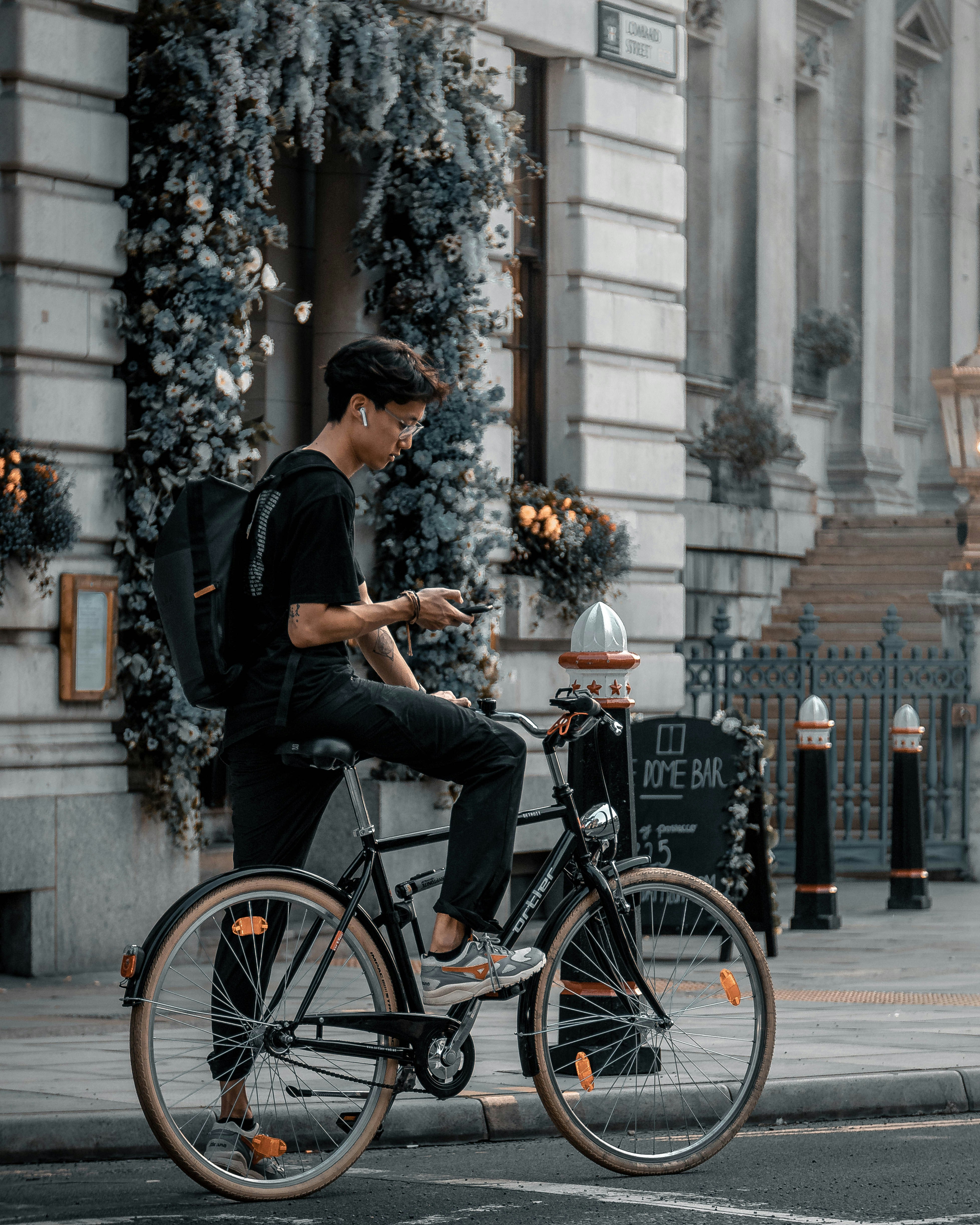 man in black t-shirt and black cap riding on black city bicycle