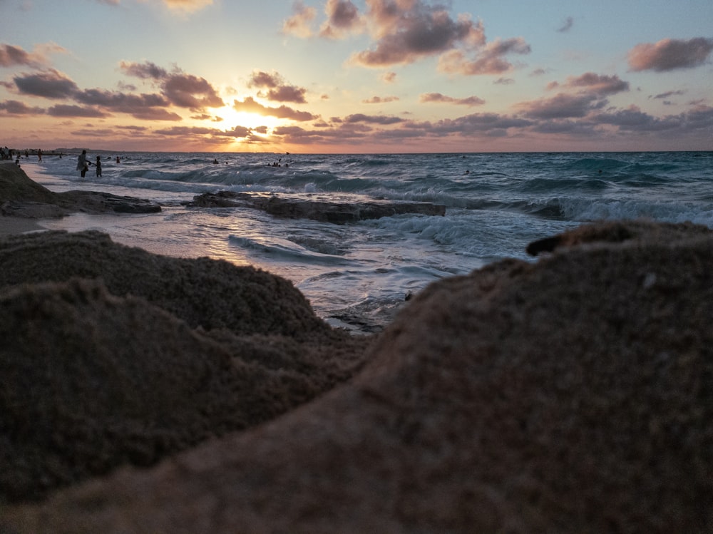 sea waves crashing on shore during sunset