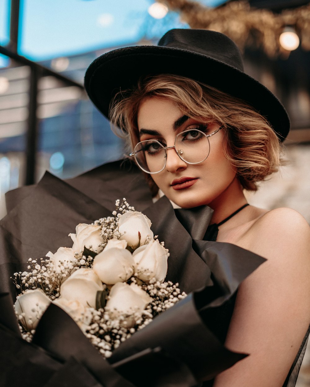 woman in black and white floral dress holding bouquet of flowers