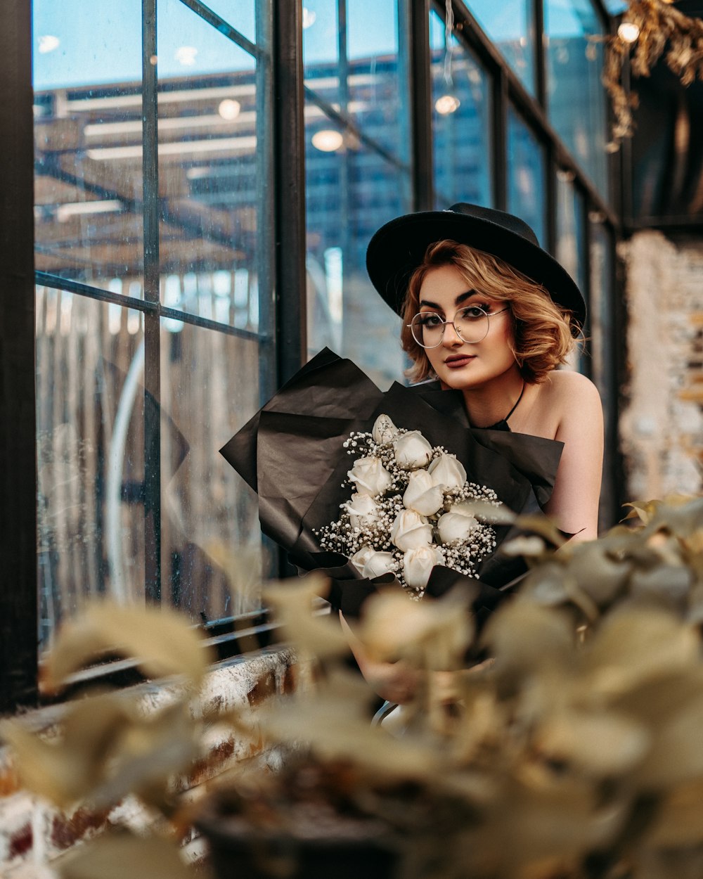 woman in black tube dress holding white flowers