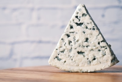Artistic shot of a wedge of blue cheese with textured rind.