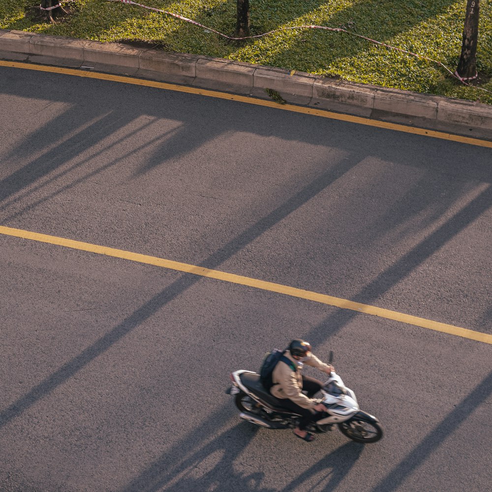 man in black jacket riding motorcycle on road during daytime