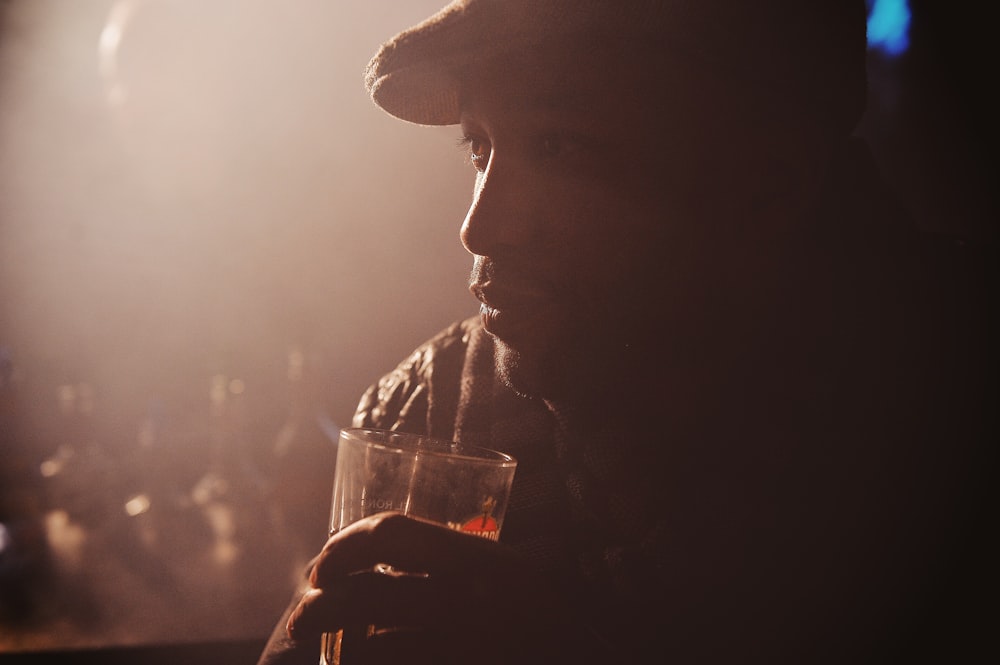 man in black jacket holding drinking glass