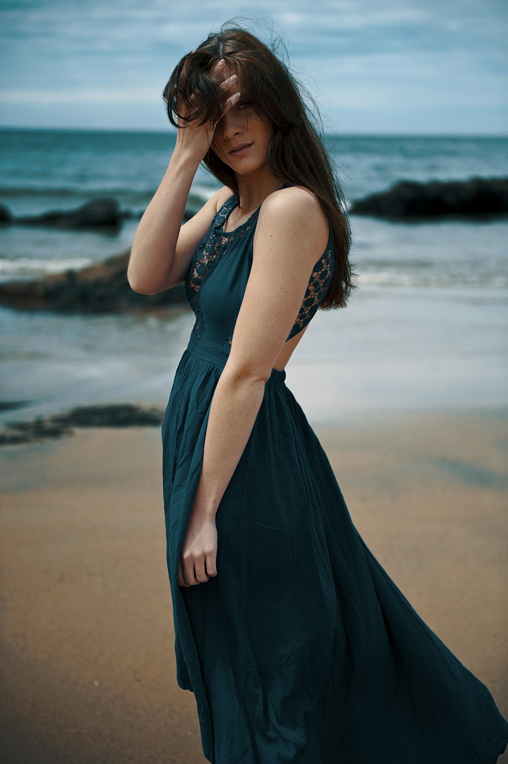 woman in blue sleeveless dress standing on beach during daytime