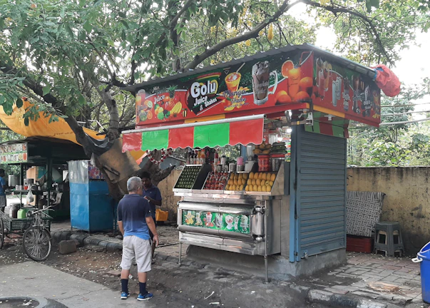 A lively street scene with a verdant juice stand blending urban culture and nature.