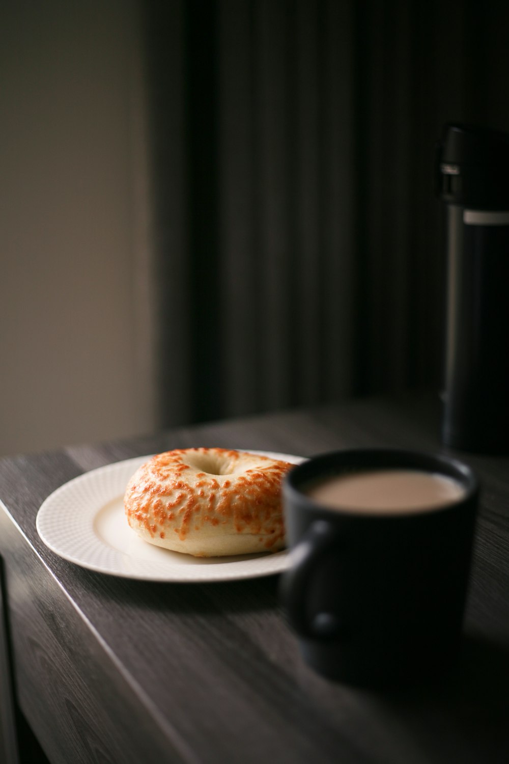 brown bread on white ceramic plate beside black ceramic mug