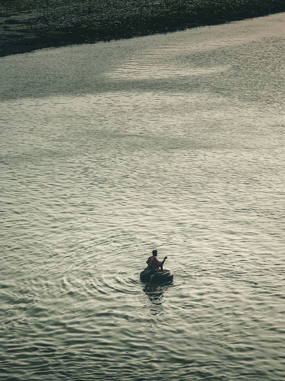 a person in a small boat on a body of water