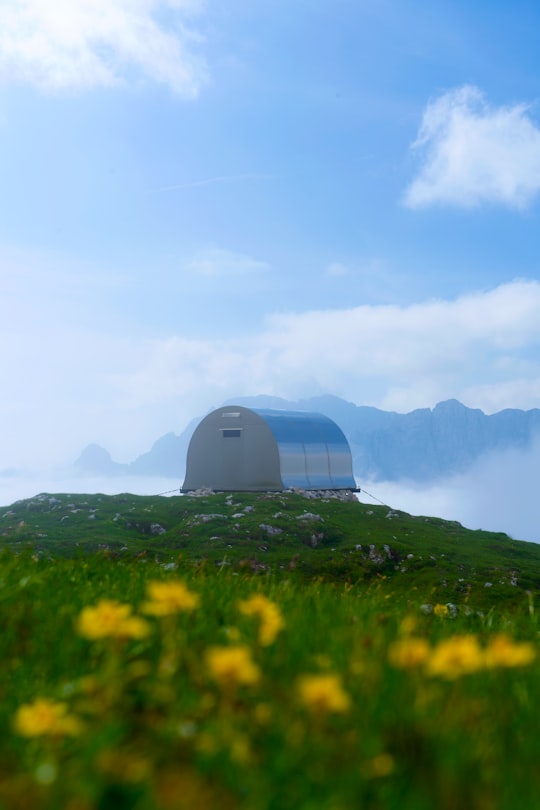white dome tent on green grass field during daytime in Julijske Alpe Slovenia