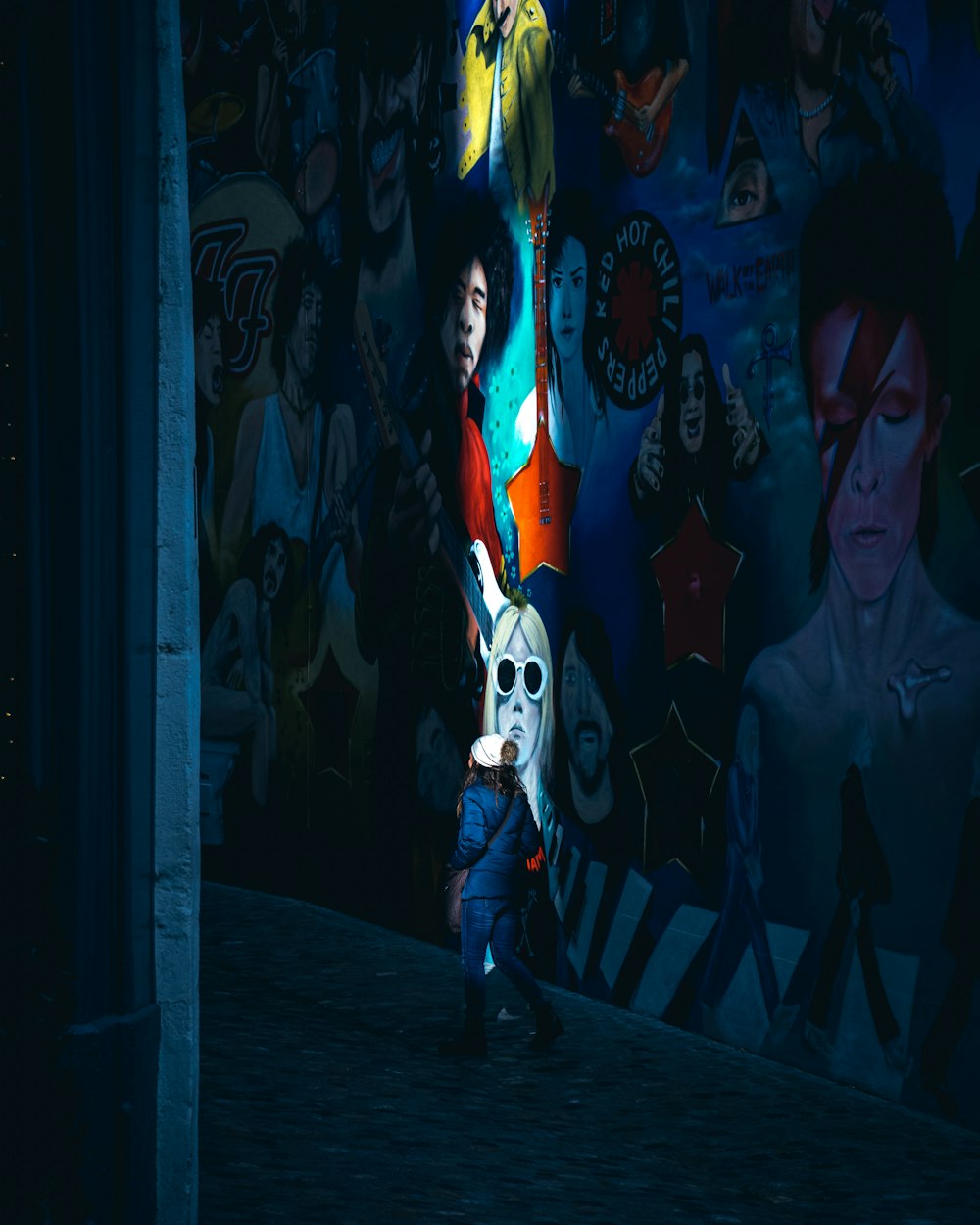 man in gray shirt standing beside woman in white and black mask graffiti